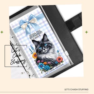 May include: A black binder with a clear pocket containing a cat-themed cash stuffing insert. The insert features a cat illustration with blue eyes, flowers, and text that reads "Spida del Risparmio 1.000 €" and "Let's Cash Stuffing". A blue bow is at the top.