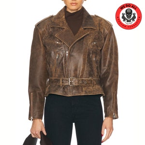 May include: A brown leather biker jacket with a belt and zip details. The jacket has a distressed look and is cropped at the waist.