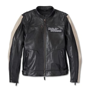 Puede incluir: Chaqueta de moto de cuero negro con cremallera, dos bolsillos delanteros y cuello alzado. La chaqueta presenta rayas beige en las mangas y el logotipo de Harley-Davidson en el pecho.