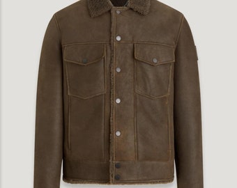 May include: A brown leather jacket with a shearling collar and lining. The jacket has two chest pockets, two side pockets, and a button-up closure. The jacket is a medium weight and is suitable for cooler weather.