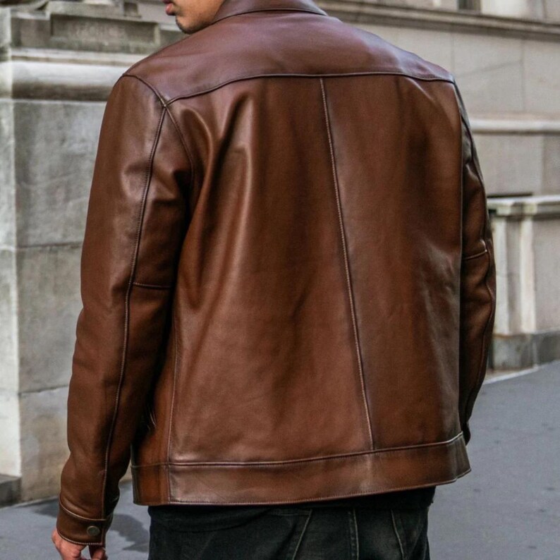 May include: A brown leather jacket with a button-up front and a classic design.