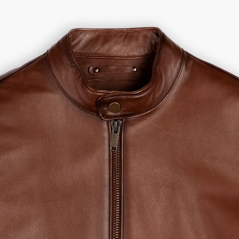 May include: A brown leather motorcycle jacket with a zipper closure and a stand-up collar.
