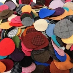 May include: A large pile of colorful felt circles in various patterns and textures. The circles are in shades of red, blue, green, yellow, brown, and gray.