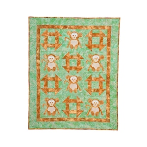 May include: A green and brown patchwork quilt with a repeating pattern of monkeys and squares. The monkeys are brown with white faces and are holding a stick.