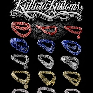 Puede incluir: Colección de pulseras de piedras preciosas en rojo, azul, plateado y dorado. Las pulseras están dispuestas sobre un fondo negro, con el nombre de la marca "Kultura Kustoms" en la parte superior. Las pulseras están adornadas con varias piedras preciosas.