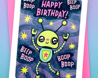 Puede incluir: Una tarjeta rosa y blanca con una ilustración de robot. El robot es verde y amarillo con una estrella en el pecho. La tarjeta dice "¡Feliz cumpleaños!" y tiene las palabras "Boop Boop" y "Beep Boop" alrededor del robot.