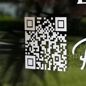 Könnte beinhalten: Ein schwarz-weißer QR-Code auf grünem Hintergrund.