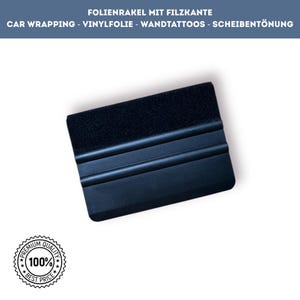 Könnte beinhalten: Schwarzer Rakel mit Filzkante, für Fahrzeugfolierung, Vinylverarbeitung und Scheibentönung. Der Text lautet "FOLIENRAKEL MIT FILZKANTE" und "CAR WRAPPING - VINYLFOLIE - WANDTATTOOS - SCHEIBENTÖNUNG". Ein "Premium Quality" Siegel ist ebenfalls zu sehen.