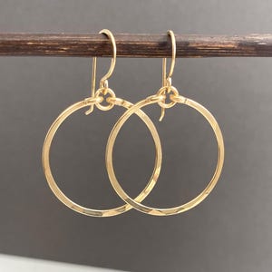 May include: A pair of gold hoop earrings with a hammered finish. The earrings are simple and elegant, and would make a great gift for any occasion.