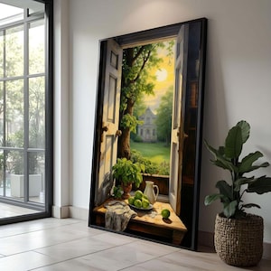 May include: A framed painting depicts an open doorway with a view of a sunny garden and a house. A wooden table in the foreground holds a vase of plants, a white pitcher, a plate of green apples, and a cloth. The artwork is displayed next to a large window and a potted plant.