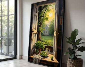 May include: A framed painting depicts an open doorway with a view of a sunny garden and a house. A wooden table in the foreground holds a vase of plants, a white pitcher, a plate of green apples, and a cloth. The artwork is displayed next to a large window and a potted plant.
