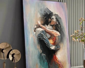 May include: An oil painting depicts a couple embracing and kissing. The artwork uses a palette of blues, pinks, and oranges, creating a romantic and emotional scene. The painting is framed in black and displayed on a white shelf.