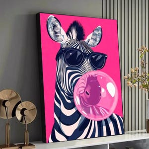 Puede incluir: Impresión en lienzo enmarcada que representa una cebra con gafas de sol soplando una burbuja de chicle rosa. La cebra tiene rayas blancas y negras sobre un fondo rosa brillante. La obra de arte es de estilo pop art moderno.