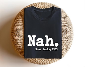 May include: Black t-shirt with white text that reads "Nah. Rosa Parks, 1955".