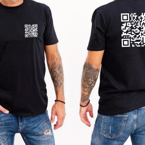 May include: A black t-shirt with a white QR code on the front and back. The model is wearing blue jeans.