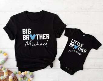 May include: Black t-shirt and onesie set with white text and a blue Mickey Mouse head. The t-shirt reads "BIG BROTHER Michael" and the onesie says "LITTLE BROTHER James". A matching set for siblings.