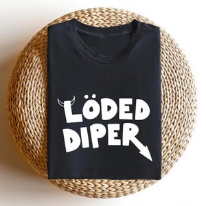 May include: Black t-shirt with white text that says "LÖDED DIPER" with a devil horn and arrow graphic.