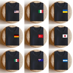 May include: Nine black t-shirts, each with a different flag patch on the chest. Flags include the USA, Italy, Ukraine, Germany, Turkey, Japan, Mexico, Australia, and Honduras. The shirts are displayed on round, woven placemats.