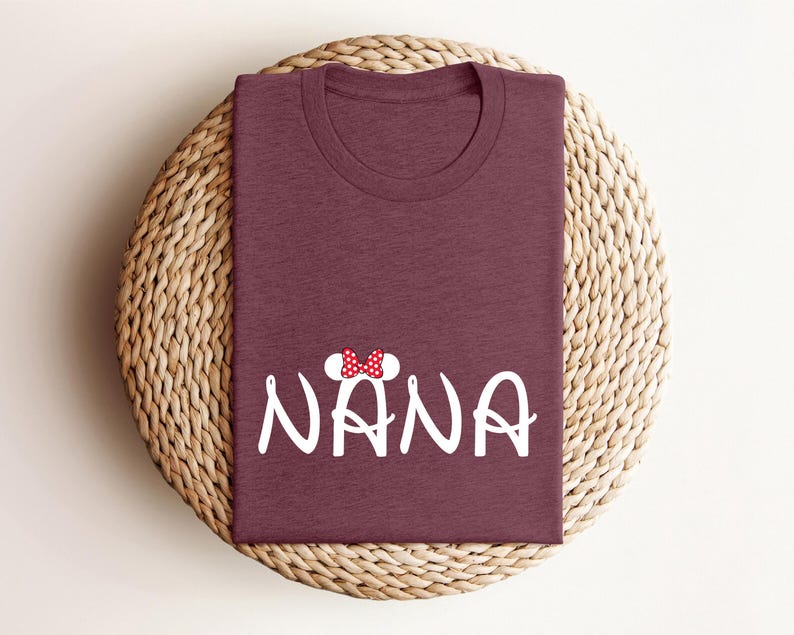 May include: Burgundy t-shirt with a white graphic of a cartoon mouse with a red bow and the word "NANA" in white.