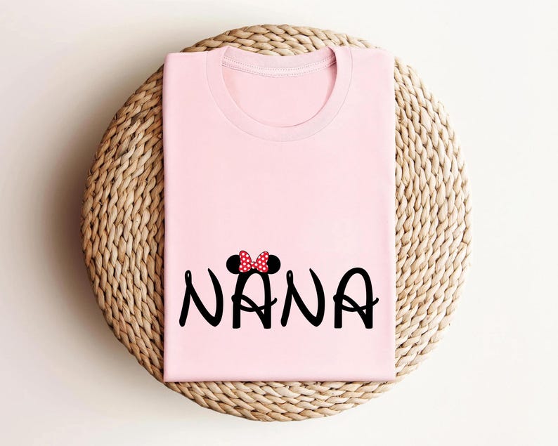 May include: Pink t-shirt with a black and red Mickey Mouse ears design and the word "NANA" in black.