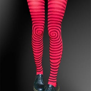 Puede incluir: Medias a rayas rojas y negras con un diseño en espiral en las rodillas. Se combinan con zapatos de cuero negro. Un accesorio de moda llamativo y original para un look único.