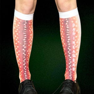 May include: Knee-high socks with a red and white spotted pattern, resembling a fish. The socks have a white band at the top and the word "DARINKAWEAR" printed vertically. Black leather shoes are worn with the socks.