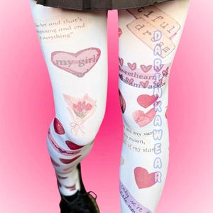 May include: White tights with various romantic graphics, including hearts, bouquets, and phrases like "my girl" and "darling." The tights are worn with black shoes and a black pleated skirt.
