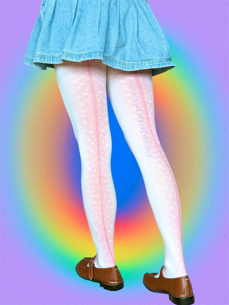 May include: White tights featuring a subtle pink speckled pattern and a vertical pink stripe running down the back of each leg. The text DARINKAWEAR is printed vertically in light blue letters on the left leg. A blue denim skirt and brown shoes.