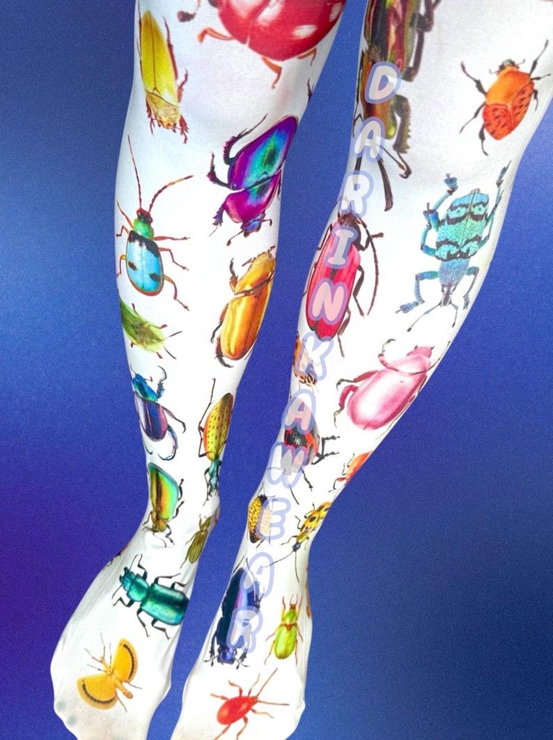 May include: White leggings featuring a vibrant, multi-colored print of various beetle species in shades of red, blue, green, yellow, and purple. The text DARINKAWAR is printed vertically in light blue letters along the right leg of the garment.
