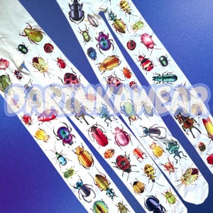 May include: White tights featuring a repeating pattern of various colorful beetles and insects in shades of red, green, blue, yellow, and metallic tones. The fabric is printed with a diverse array of beetle species across the entire length.