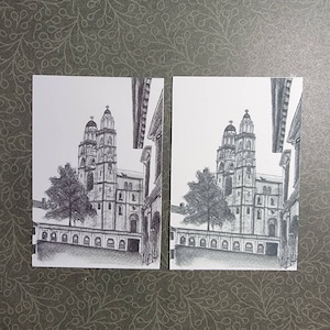 May include: A black and white drawing of a church with two towers. The drawing is on a white background and is framed in a white mat.