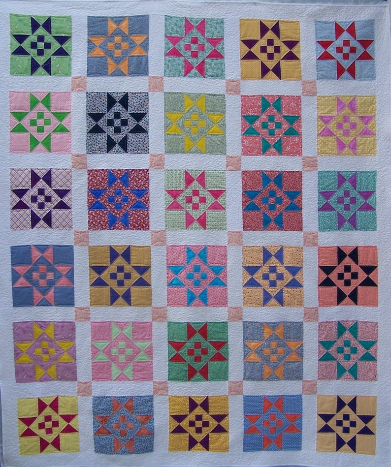 May include: A quilt with a patchwork design featuring a variety of colors and patterns. Each square is a different design with a star in the center. The quilt is made up of 36 squares.