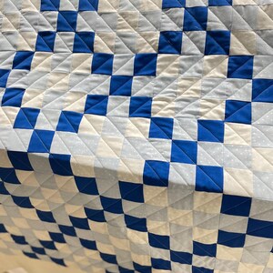 Fresh off the longarm, I quilted straight lines in a V shape running all the way down the quilt between two blocks.