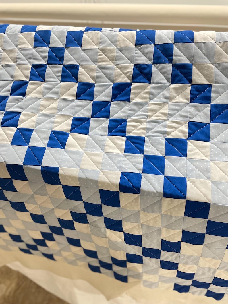 Fresh off the longarm, I quilted straight lines in a V shape running all the way down the quilt between two blocks.
