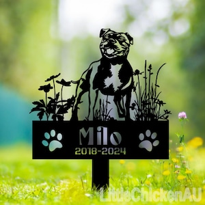 May include: Black metal silhouette of a dog standing in a field of grass with flowers. The sign reads "Milo 2018-2024" with paw prints on either side.