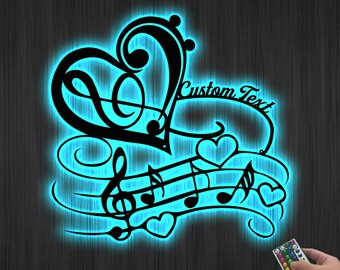 Puede incluir: Un diseño de notas musicales negras en forma de corazón con un mando a distancia. El diseño incluye notas musicales, claves de sol y corazones. El diseño está iluminado en un color azul brillante. El texto "Custom Text" está incluido en el diseño.