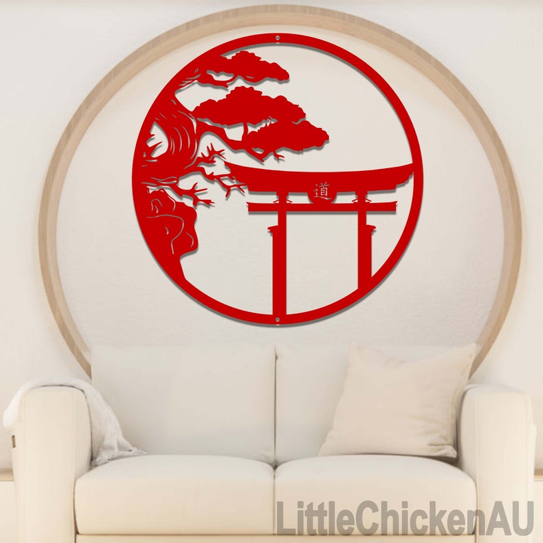 May include: A red metal wall art piece featuring a Japanese torii gate and a stylized tree within a circular frame. The artwork is mounted on a light-colored wall above a white sofa. The text "LittleChickenAU" is visible at the bottom right.
