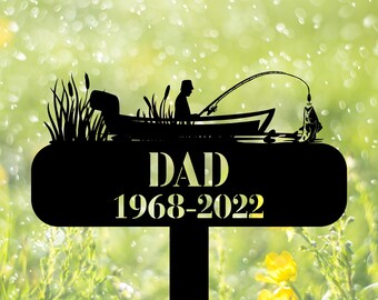 May include: Black metal silhouette of a person fishing from a boat with the text "DAD 1968-2022" on a black oval sign.