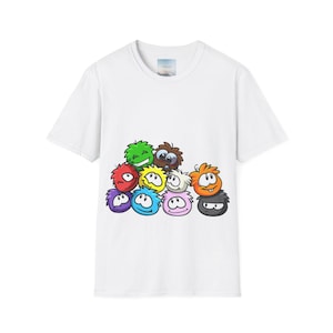 May include: White t-shirt with a colorful graphic print of cartoon characters. The characters are stacked on top of each other and have different colors and expressions.