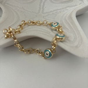 Protection bracelet with Turkish eye charms on a gold chain, amulet against the evil eye.