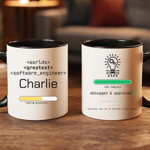 May include: Two white coffee mugs with black handles and rims. One mug has the text "<worlds> <greatest> <software_engineer> Charlie" with a loading bar. The other mug has a lightbulb graphic and the text "100% Complete debugged & approved".