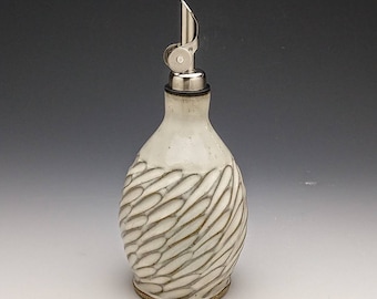 May include: White ceramic olive oil bottle with a silver pour spout and a swirling, textured design.