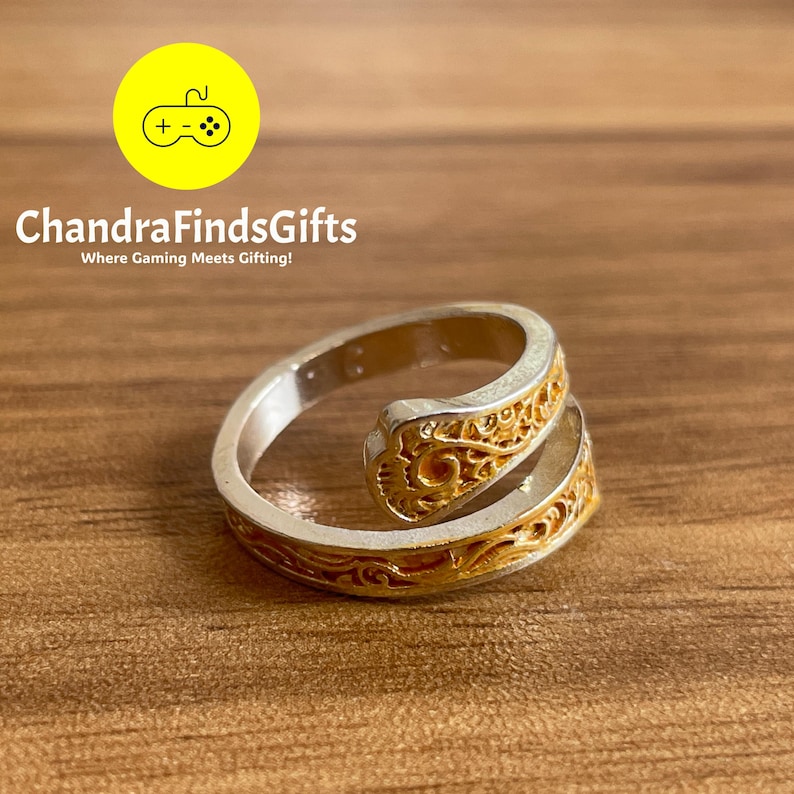 a gold and silver ring sitting on top of a wooden table