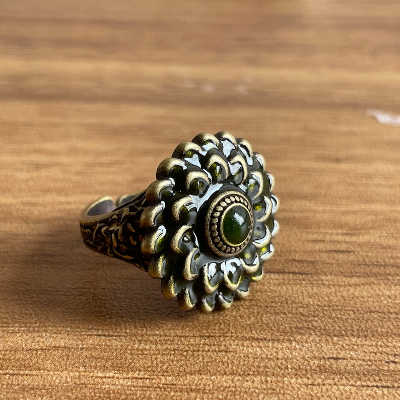 a silver ring with a green stone in the center