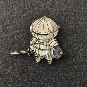a pin with a cartoon character holding a sword