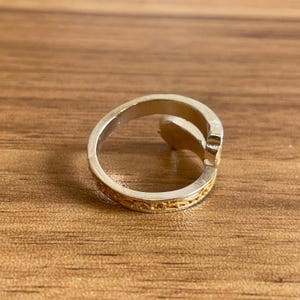 a silver ring sitting on top of a wooden table