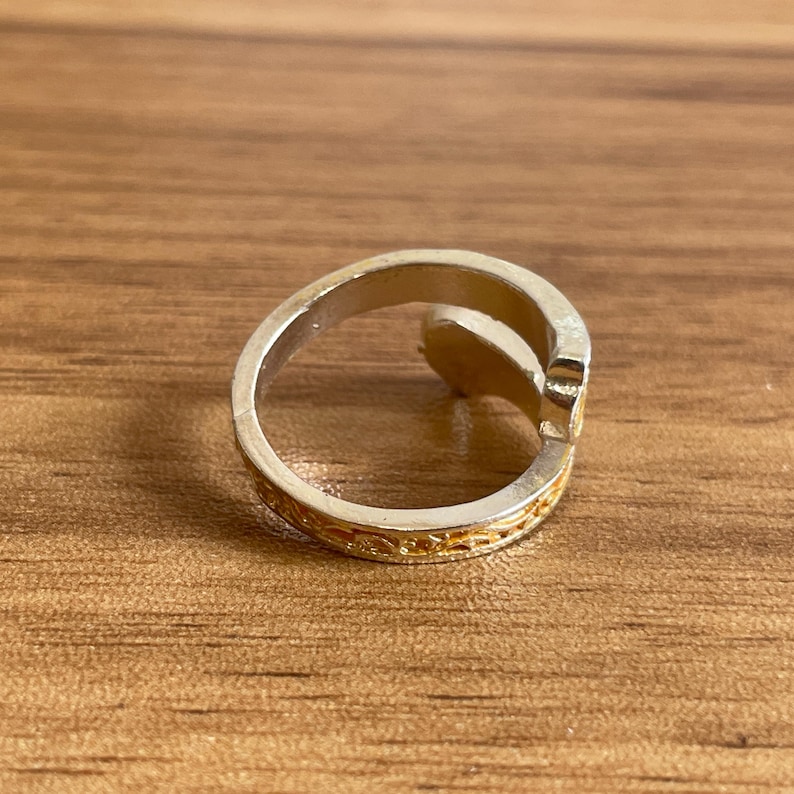 a silver ring sitting on top of a wooden table
