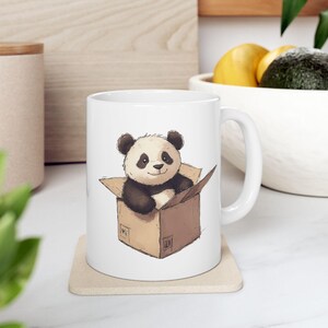 Niedliche Panda-Tasse, lustiger Panda im Kasten, Panda im Karton-Box-Bild sitzend, niedliches Tierdesign, schrullige Geschenkidee, Panda-Liebhaber-Geschenkbecher