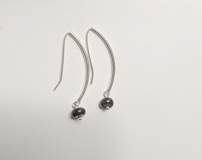 Black Onyx disc dangle earrings.  Discs hang from curved sterling silver tubes with self made earwires.  Lightweight,