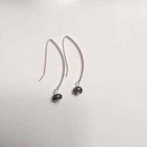 Black Onyx disc dangle earrings.  Discs hang from curved sterling silver tubes with self made earwires.  Lightweight,